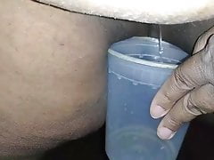 Black amateur pissing in a cup for her white daddy